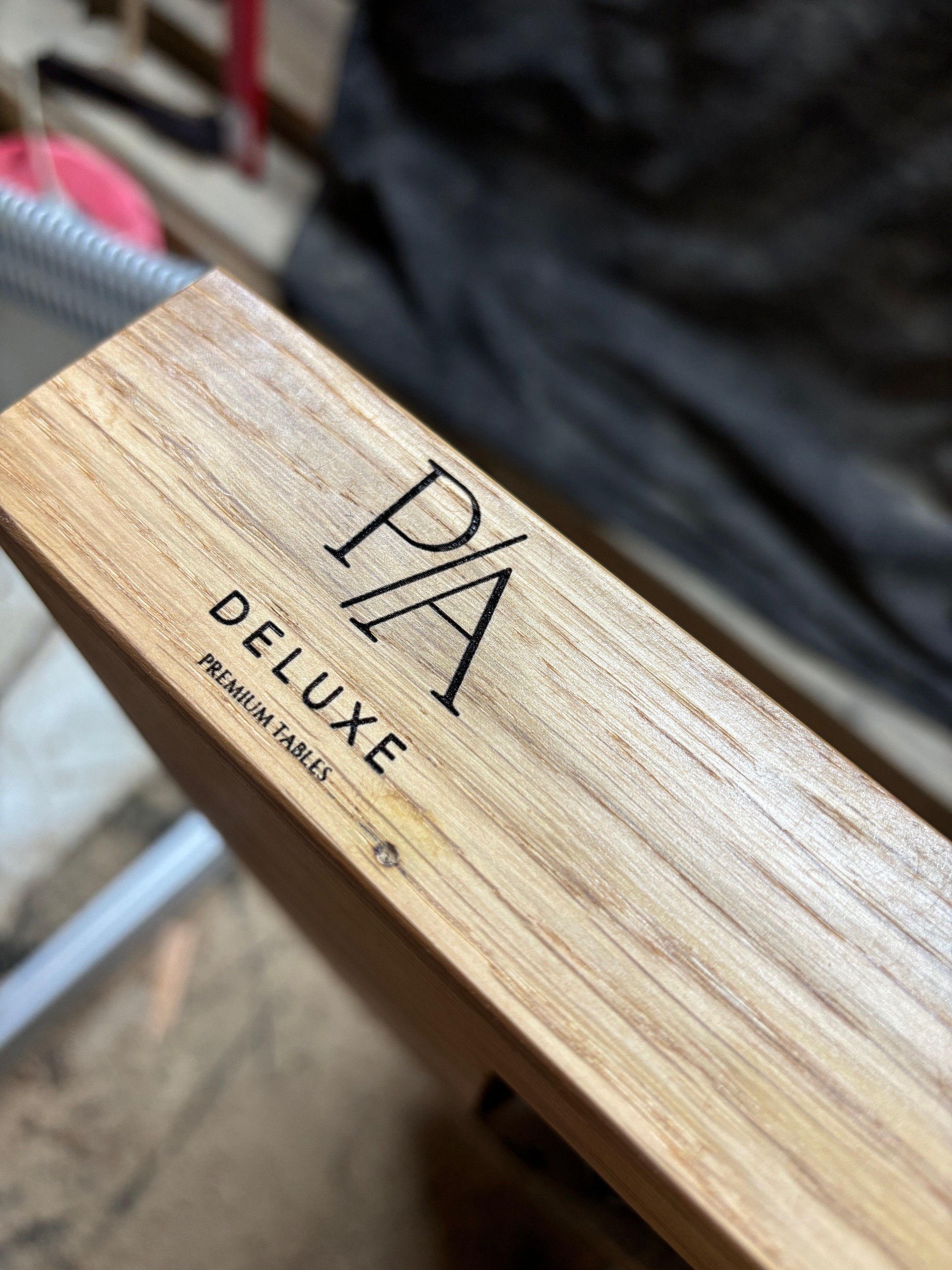 Logo P/A Deluxe vyryté do masivní desky